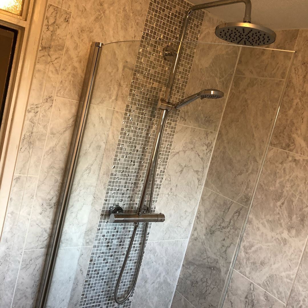 Thermostatic shower valve and rainfall head installed over mosaic tile